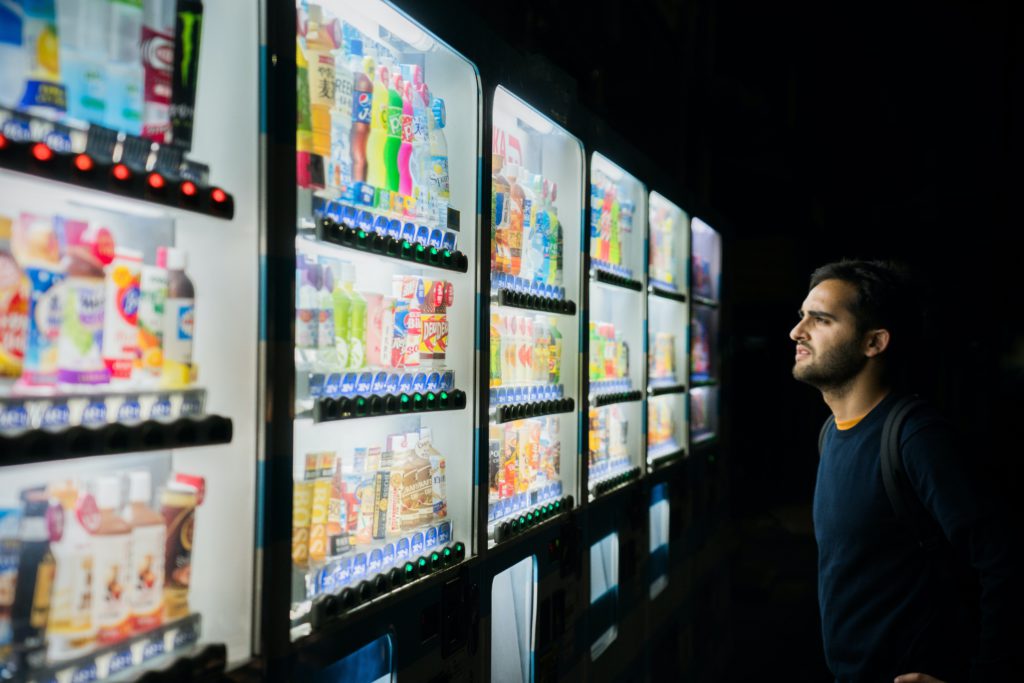 Man stares full of refreshments fridges, confused of what to choose